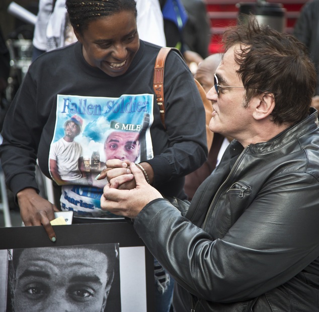 Kimberly Griffin, left, holds hands with film director Quentin Tarantino after she recalled memories of her son Kimoni Davis, during a public reading of the names of people who have died at the hands of police nationwide, Thursday, Oct. 22, 2015, at Times Square, in New York. The protest marked the start of three days of protests and marches speaking out against violence at the hands of law enforcement. (AP Photo/Bebeto Matthews)