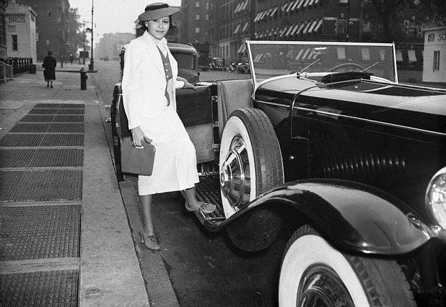  A smiling, Marva Trotter "the most beautiful woman in Harlem" steps into her Duesenberg in Harlem, 1940's.